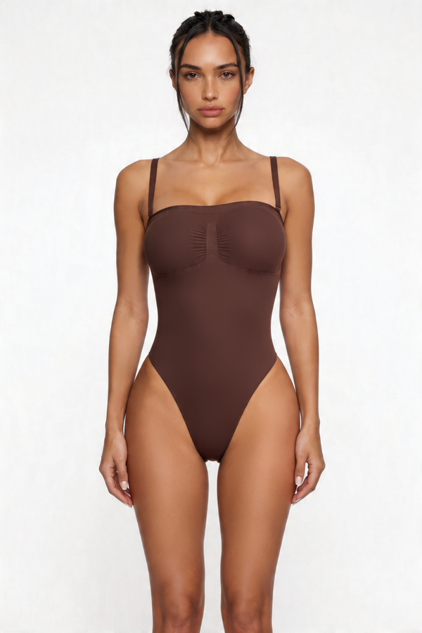 Woman wearing a brown shapewear bodysuit on a white background