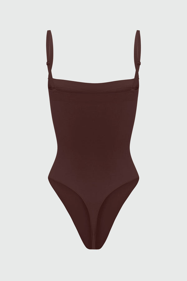 Black shapewear bodysuit with thin straps on a light gray background