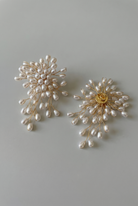 Pair of pearl earrings on a light gray background