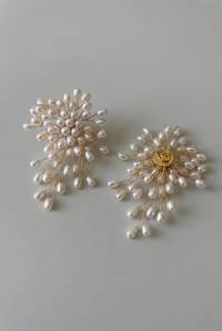 Pair of pearl earrings on a light gray background