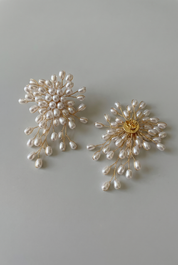 Pair of pearl earrings on a light gray background